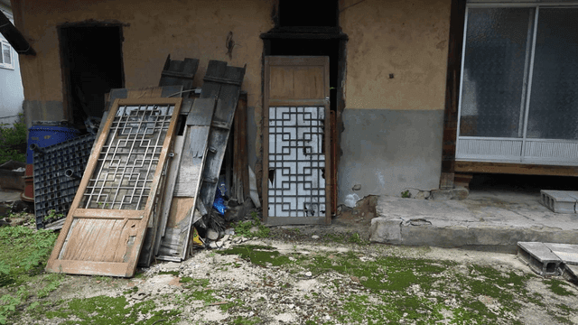Old house with wooden door and debris