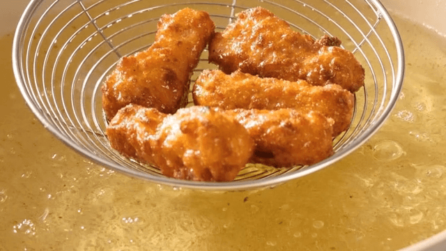 Golden fried chicken sizzling in hot oil