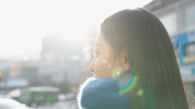 Woman walking in the street with sunlight