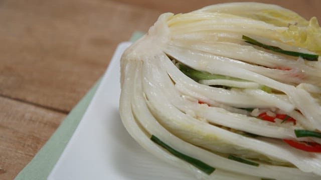 Fresh cabbage kimchi on a plate on a wooden table