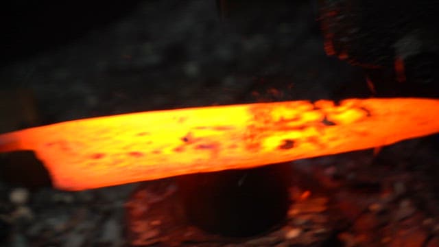 Craftsman forging a heated metal blade