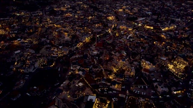 Village Scene Illuminated by Lights in Every House at Dusk