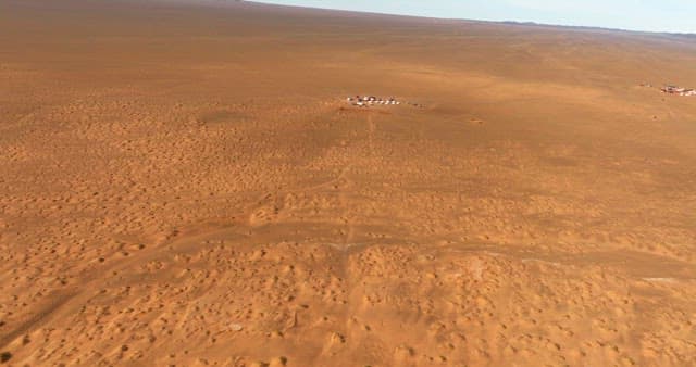 Vast desert landscape with distant settlement