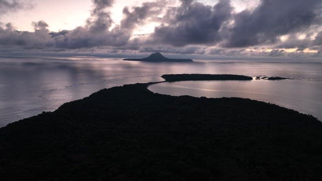 Island at dawn with clouds and ocean