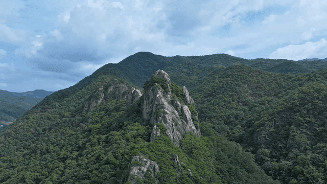구름 낀 하늘 아래 장엄한 산봉우리