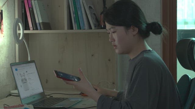 집의 방안에서 핸드폰으로 통화를 하는 여자