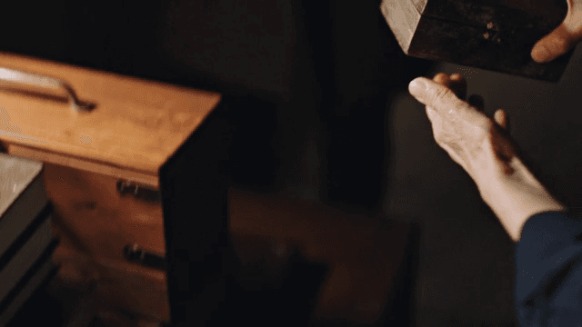 나무 상자를 꺼내 건네는 손