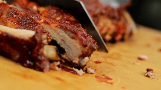 Appetizing grilled ribs cut on a wooden cutting board