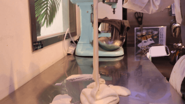 테이블에 반죽을 붓는 사람