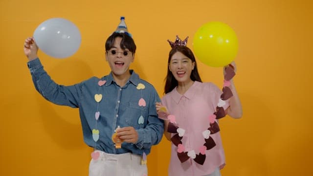 풍선을 들고 축하하는 두 명의 행복한 사람