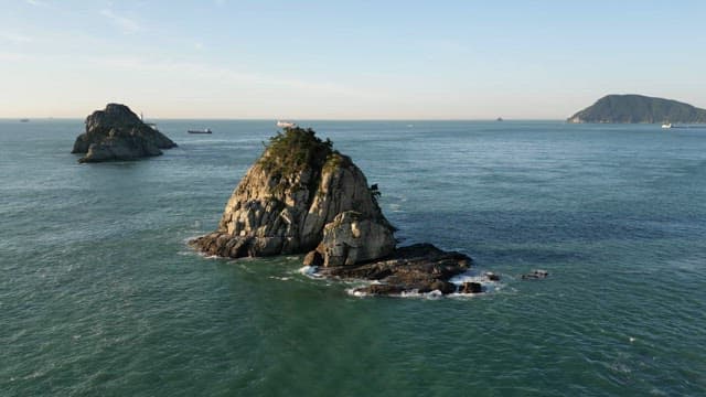 잔잔한 바다에 둘러싸인 바위섬