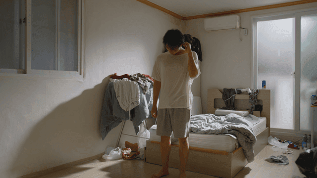 지저분한 침실에 서 있는 남자