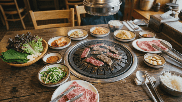 Beef on grill plate accompanied by various side dishes