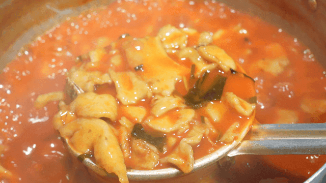 Ladle to scoop up spicy dumplings boiling in pot