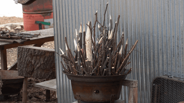 뾰족하게 깎인 나무 조각품들이 담긴 금속 바구니