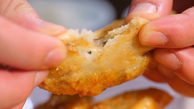 Crispy dumpling being torn open