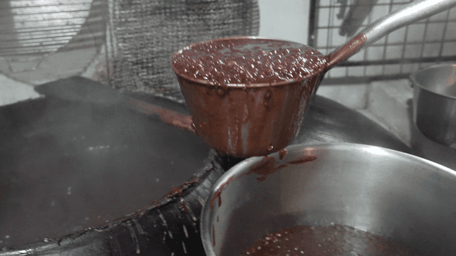 Red bean porridge being ladled into a pot