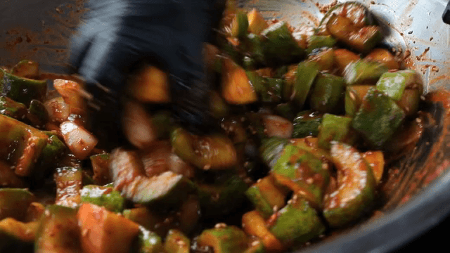 금속 그릇에서 오이 김치를 버무리기