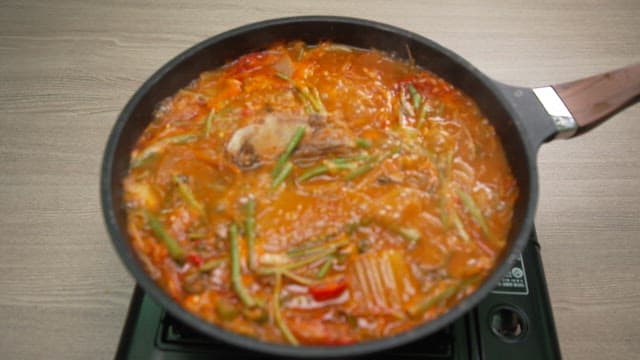 Spicy fish stew boiling on the stove