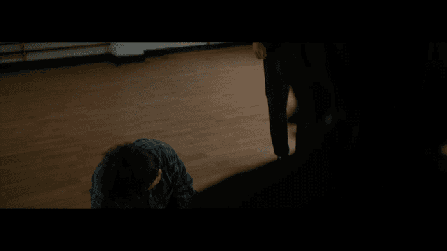 Person kneeling on a wooden floor