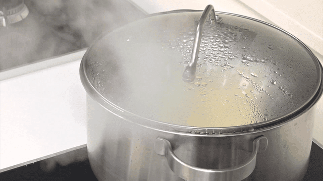 Pot boiling on a stove with steam