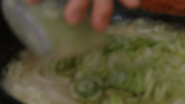 프라이팬에서 무채와 함께 대파를 볶는 모습