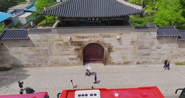 Traditional Korean gate with people passing by