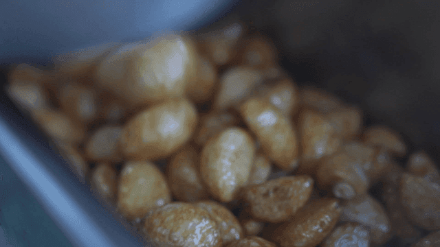 Golden roasted garlic cloves in a pan