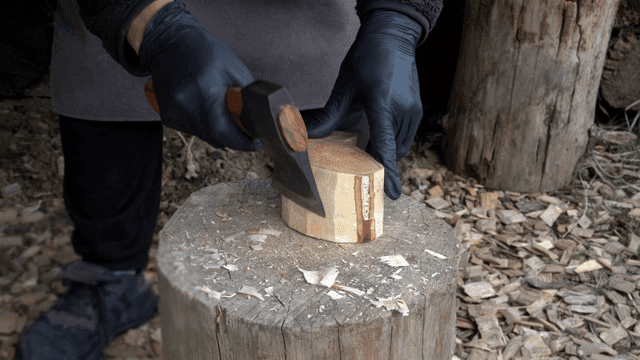 야외에서 도끼로 나무를 자르는 사람