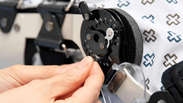 Hands precisely adjusting patient leg orthosis medical device