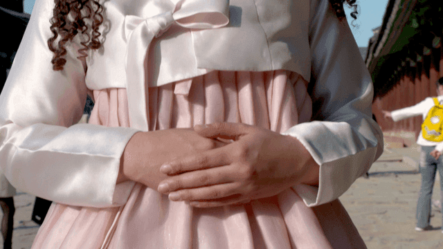 Woman wearing traditional Korean hanbok in light red