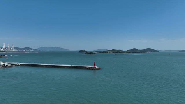 Calm sea with distant islands and a lighthouse