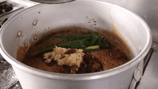 끓는 냄비에 북어포 가루를 추가하는 장면