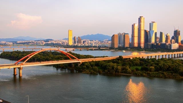 Cityscape at dusk with illuminated skyline and river