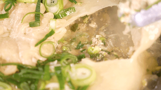 Dumpling soup with wrapper peeled off with tongs