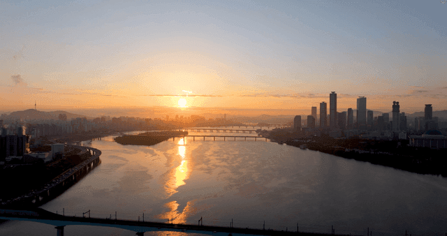 강이 있는 도시 스카이라인 위의 일출