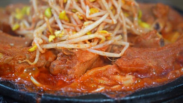 조리되고 있는 뜨겁고 매운 돼지갈비와 콩나물