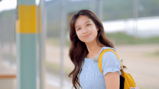 A young woman smiling at a train station