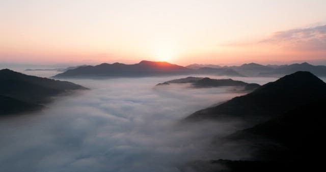 Sky Colored by Sunrise over Foggy Mountains