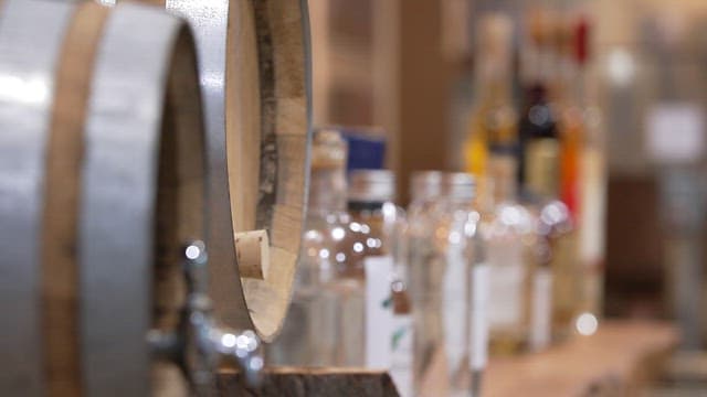 나무 테이블 위의 양조통과 다양한 술병들