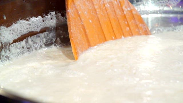 주걱으로 용기 속 콩물 저어주기