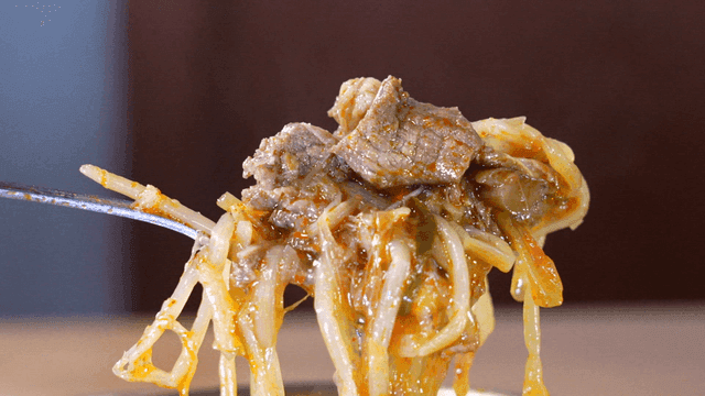 Serving spicy steaming Korean beef soup with spoon