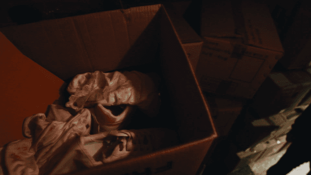 Clothes and shoes in boxes stacked in dark room