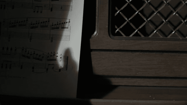 어두운 실내에서 악보를 넘기는 손
