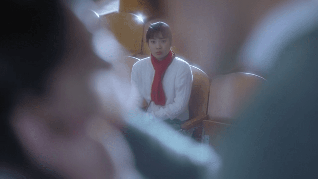 Woman watching people on stage from her theater seat