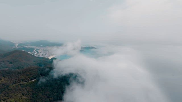 짙은 안개가 낀 산과 해안 마을