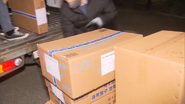 Workers Transporting Boxes Containing CSAT Test Papers at Night