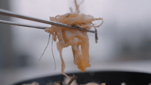 Lifting fresh Raw Fish Bibimbap bowl with chopsticks
