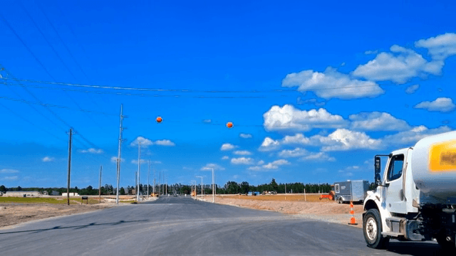 맑은 하늘 아래 새로 포장된 도로 위 트럭