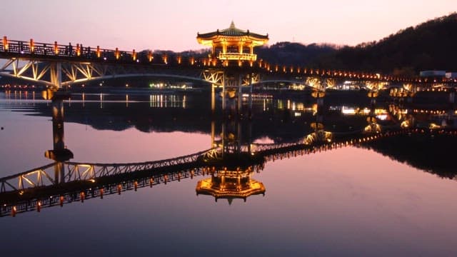 Illuminated bridge and pavilion at night